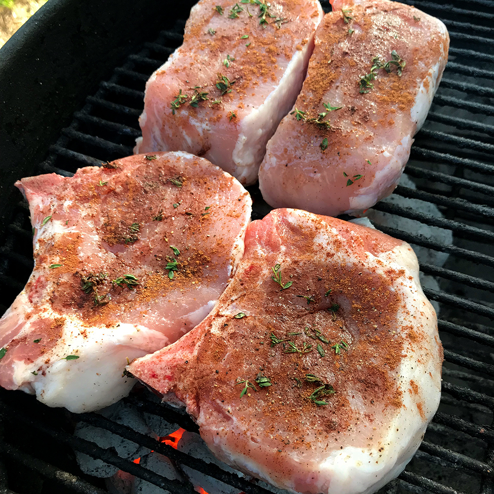 Pork chops on the grill with cinnamon/thyme rub.