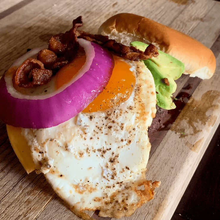 The Caveman is loaded with red onion, bacon, fried egg, avocado, Havarti and American cheeses and a slather of mustard.