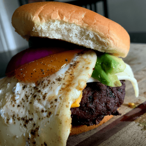 The Caveman is loaded with red onion, bacon, fried egg, avocado, Havarti and American cheeses and a slather of mustard.