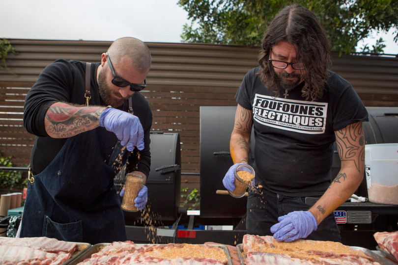 Ronnie Lee and Dave Grohl rub a combination of seasonings on pork ribs