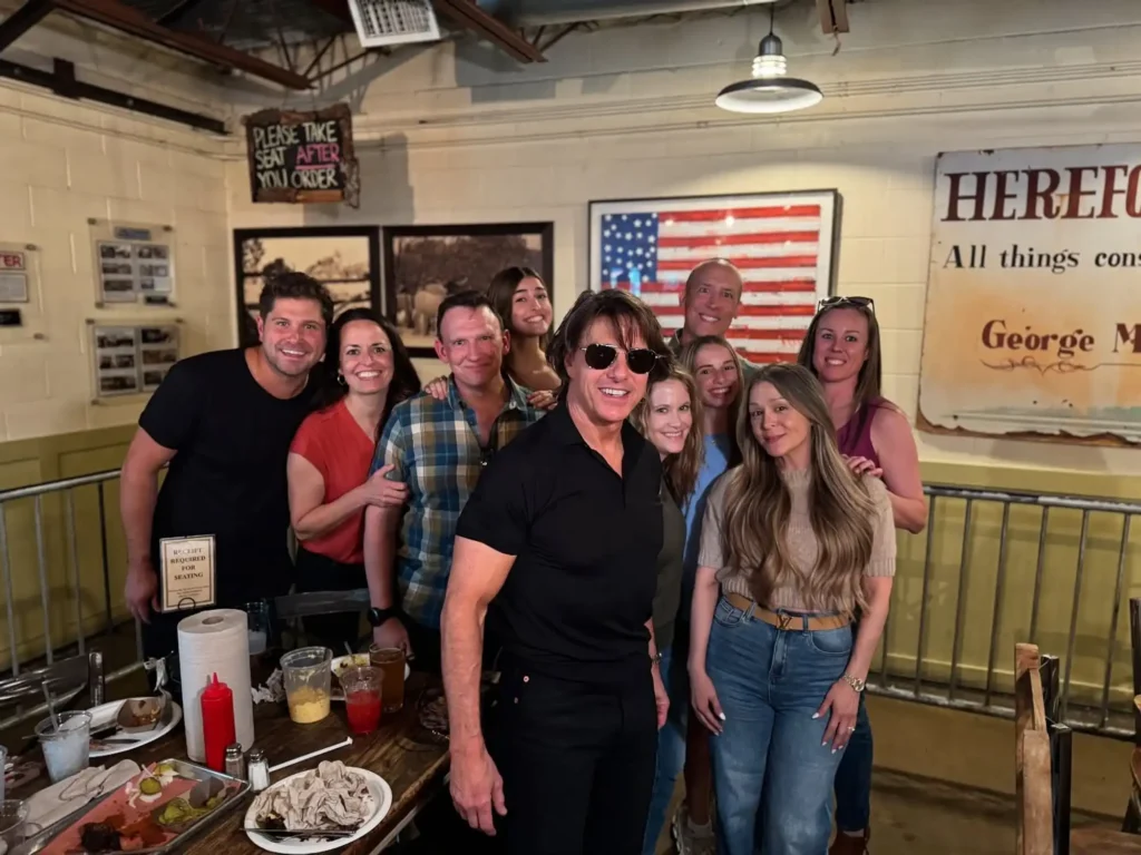 Tom Cruise surrounded by friends at Pecan Lodge BBQ restaurant in Dallas, Texas.